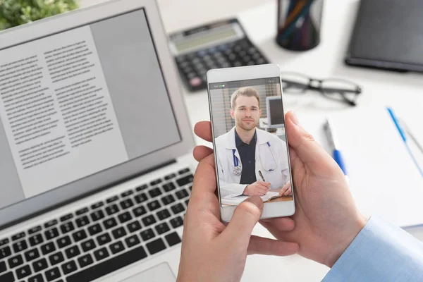 Akıllı telefon ekranında steteskoplu bir doktor. Teletıp ya da tele sağlık kavramı.