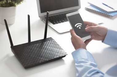 Kablosuz yönlendirici veya erişim noktası. Smartphone ile kablosuz simgesi kullanan adam