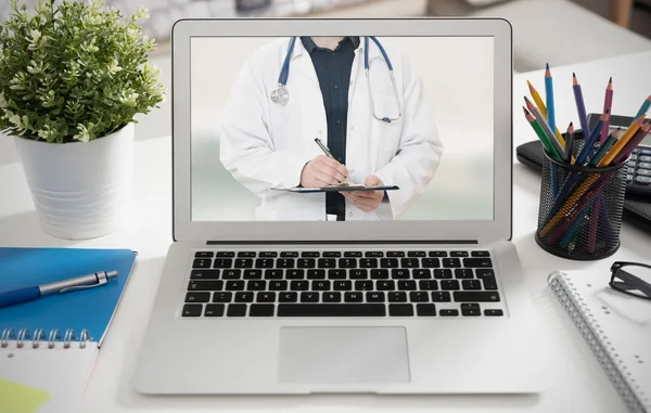 Bilgisayar dizüstü bilgisayar ekranında bir stetoskop ile doktor. Teletıp veya telehealth kavramı.