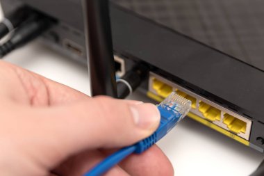 Adam internet kablosu yönlendiriciye takılan.