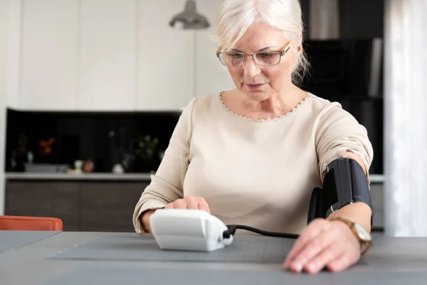 Senior volwassen vrouw meten van bloeddruk — Stockfoto