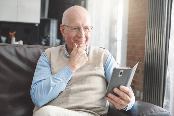 Lachende Senior man met behulp van een smartphone — Stockfoto