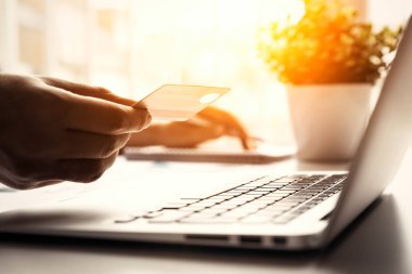 İnternet alışverişi sırasında kredi kartı kullanan adam