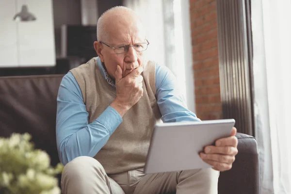 Verward Senior man met behulp van een digitale Tablet — Stockfoto