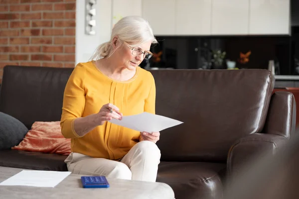 Senior vrouw met Rekenmachine en rekeningen tellen — Stockfoto