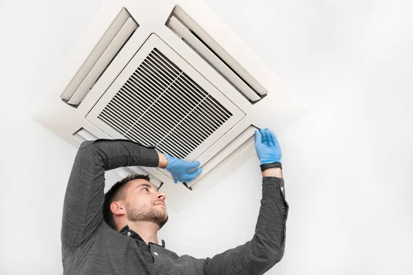 Young technician repairing air conditioner — Stock Photo, Image