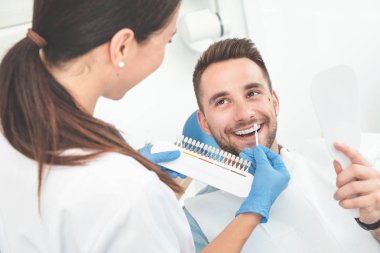 Stomatolojinin kliniğinde yakışıklı genç adam