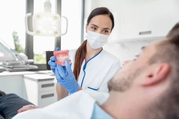 Kobieta dentysta z próbkami szczęk model zęba — Zdjęcie stockowe
