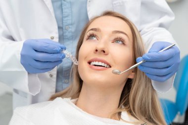 Dişçileri muayene eden bir kadın. Diş beyazlatma, diş bakımı konsepti