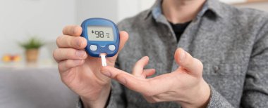 Genç adam kan şekeri seviyesini ölçer. Glukometre kullanan diyabet.