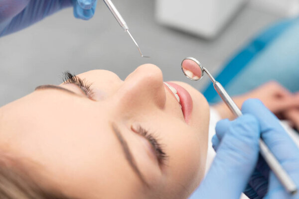Woman having teeth examined at dentists. Teeth whitening, dental care concept