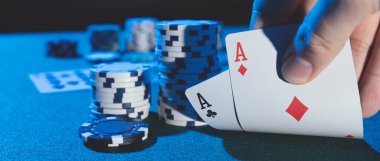 Adam kumarhanede poker oynuyor. Elinde kartlar, kumar konsepti. Kopyalama alanı olan geniş resim arkaplanı.