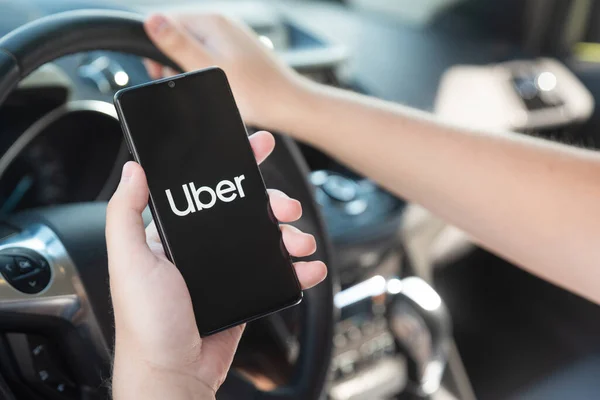 Wroclaw ポーランド 2020年8月25日 車の中でスマートフォンを保持するUberドライバー Uberは Ubran輸送のシェアリングエコノミーサービスです — ストック写真