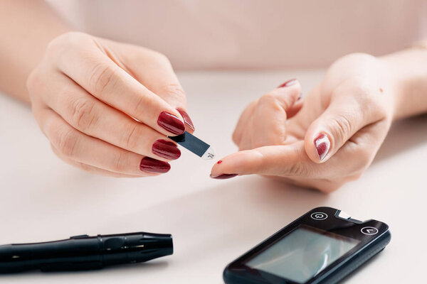 Woman checking blood sugar level. Diabetes health care concept