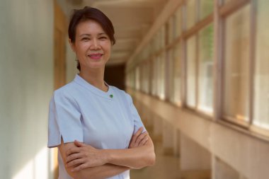 Gülümseyen portresi yaşlı hemşire hastane balkon, ayakta