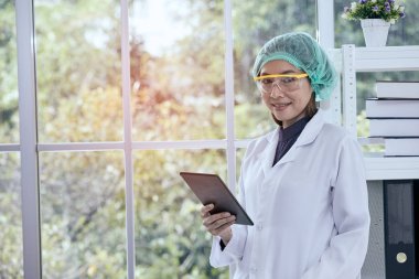 Taplet onay için sonuç tutarak ve gülümseyen kadın bilim adamı