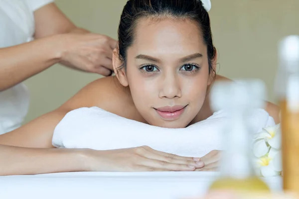 Beyaz yatakta Spa tedavisi alırken gülümseyen çekici genç Asyalı kadının yakın çekim