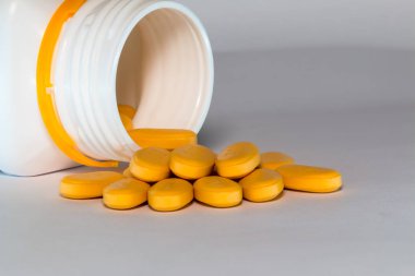 Beyaz şişeden dökülen birçok doz ilaç 