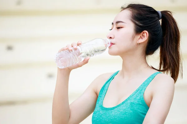 Asian beautiful sportswoman drinking mineral water