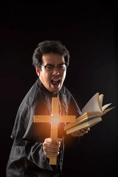 Dark Tone Rim Light Priest Show Crucifix While Holding Bible — Stock Photo, Image