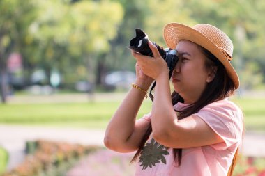 Sırt çantalı güzel Asyalı kadınlar sıcak ışık altında ormanda kameraya nişan alırlar.