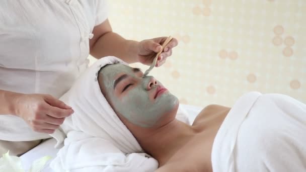 Zbliżenie Górę Kosmetyczka Stosując Gliny Twarzy Maska Młody Azji Kobieta — Wideo stockowe