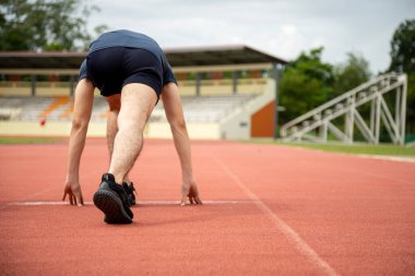 Asyalı erkek koşucu Bunch başlangıç pozisyonunda yarışma görünümünde arkadan hareket etmeye başlar