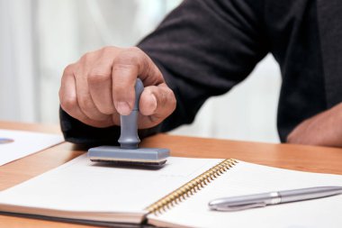 Asyalı işadamı belgeye onaylı damga vuruyor ve damgalıyor