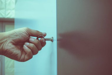 Asyalı erkek teknisyen el ele tutuşup bakımı için makine kılıfını açmak üzere gümüş anahtarı çeviriyor.