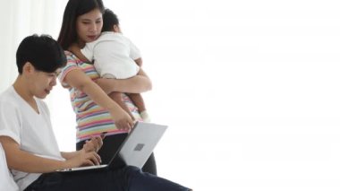 Asyalı lezbiyen çift, küçük erkek bebek için online alışveriş yapıyor. Bebek gösteren dizüstü bilgisayarı olan genç bir kadın yaşlı kadından emir almak için yataktaydı.