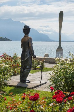 Vevey, İsviçre - Eylül 02: Charlie Chaplin anıt Geneva Gölü, İsviçre üzerinde 02 Eylül 2018 dışına taşıyorsa arka plan dev çatal Vevey (Vaud) kıyısındaki üzerinde
