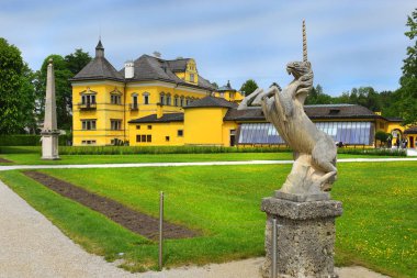Salzburg, Avusturya - 25 Mayıs 2019 : Salzburg Başpiskoposunun yazlık konutu Hellbrunn Sarayı'nın arka planında parkta tek boynuzlu at heykeli