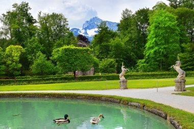 Salzburg, Avusturya - 25 Mayıs 2019 : Helbrunn Dağı'nın arka planında parkta tek boynuzlu at heykelleri, Hellbrunn Sarayı - Salzburg Başpiskoposunun yazlık konutu