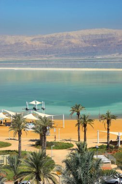 Ölü Deniz, Ein Bokek, İsrail - 14 Temmuz 2019 : Tatilciler ve turistler Ölü Deniz'de yıkanır, tatil beldesi Ein Bokek'te halk plajı