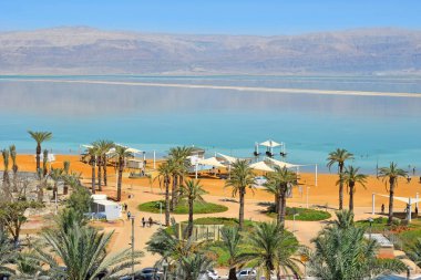 Ölü Deniz, Ein Bokek, İsrail - 14 Temmuz 2019 : Tatilciler ve turistler Ölü Deniz'de yıkanır, tatil beldesi Ein Bokek'te halk plajı