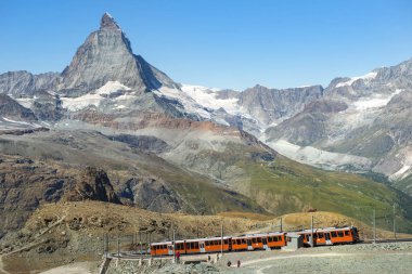 İsviçre Alplerinde Matterhorn zirvesinin arka planında kırmızı tren (Pennine Alpleri) )