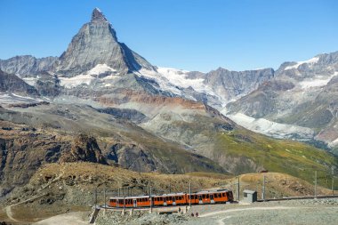 İsviçre Alplerinde Matterhorn zirvesinin arka planında kırmızı tren (Pennine Alpleri) )