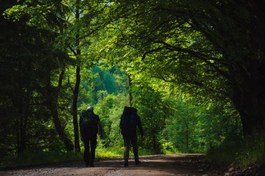 İki arkadaş sırt çantaları ile dağlarda seyahat
