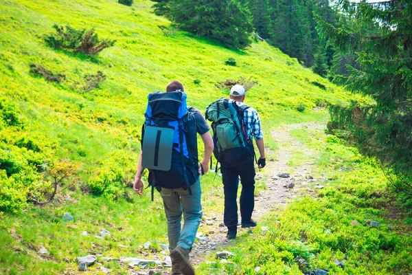 İki arkadaş sırt çantaları ile dağlarda seyahat — Stok fotoğraf