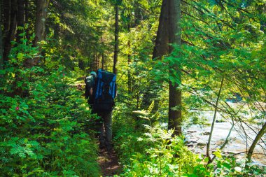 İki arkadaş sırt çantaları ile dağlarda seyahat