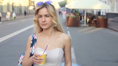 Gülümseyen ve sokakta dans kahve, holding neşeli bir kız. Sürekli çekim.