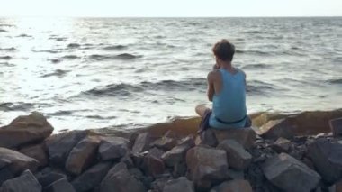 Erkek gömlek ve mızıka sahilde oynarken güneş gözlüğü. Arkadan görüntülemek.