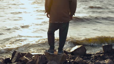 Deniz kıyısında mutlu adam rahatlatıcı. Kaldır ellerini havada.