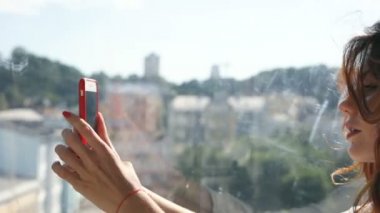 Selfies, dönme dolap içinde otururken alarak güzel, kıvırcık saçlı kadın.