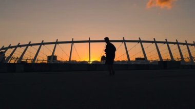 Adam holding kaykay yürüme Silhouttet. Ağır çekim.