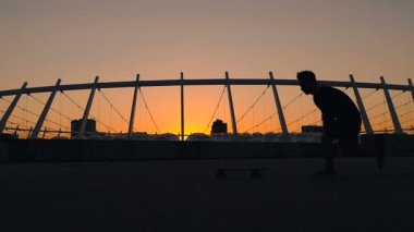 Adam çalışan silüeti onun kaykay götürün.