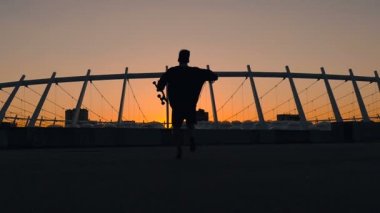 Slohoutte mutlu adamın paten holding, atlama ve having fun.