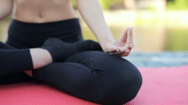 女人坐在瑜伽垫上 手里拿着莲花运动的焦点 — 图库视频影像