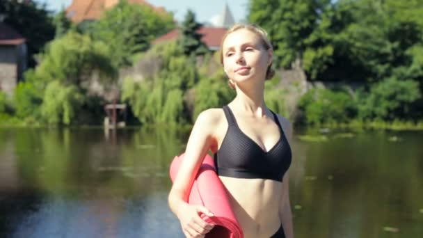 Slim Woman Standing Holding Yoga Mat Relaxing — Stock Video