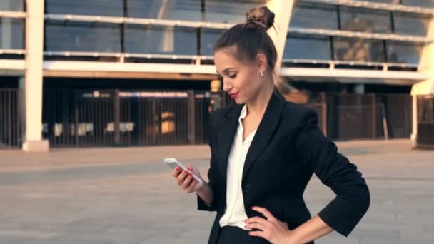 Feliz Sorridente Mulher Negócios Standilg Segurando Smartphone Desfrutando Boas Notícias — Vídeo de Stock